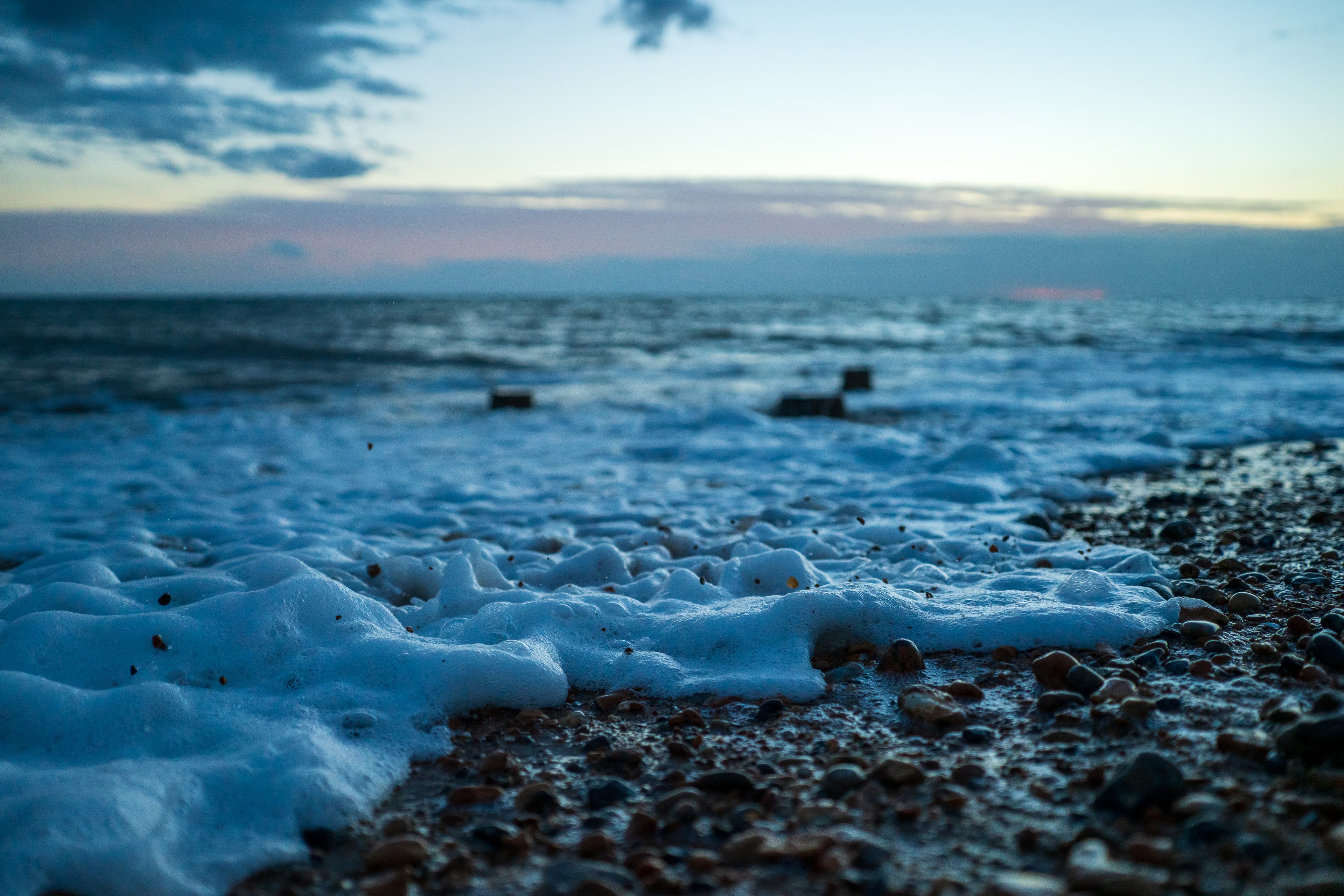 Stones thrown into the air by the splash of waves lapping at the shore, Seaford Beach, East Sussex